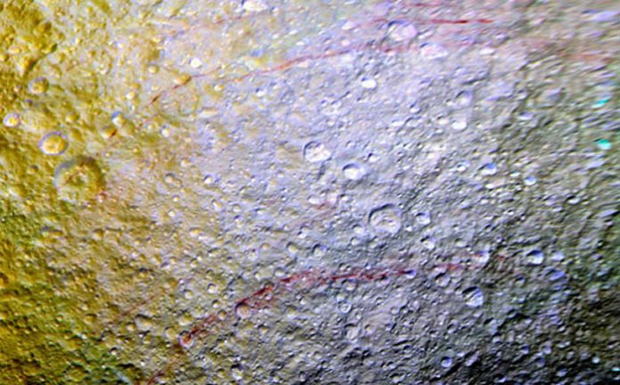 Esta imagen con color mejorado muestra los impresionantes arcos rojos que cortan la superficie de hielo de Tetis. Esta imagen con color mejorado muestra los impresionantes arcos rojos que cortan la superficie de hielo de Tetis.