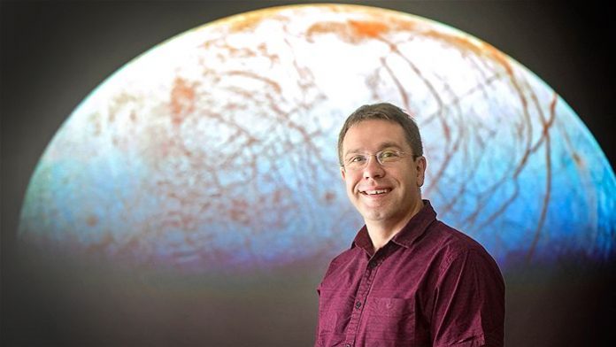 El Dr Jonti Horner delante de una imagen del satélite de Júpiter, Europa. El Dr Jonti Horner delante de una imagen del satélite de Júpiter, Europa.